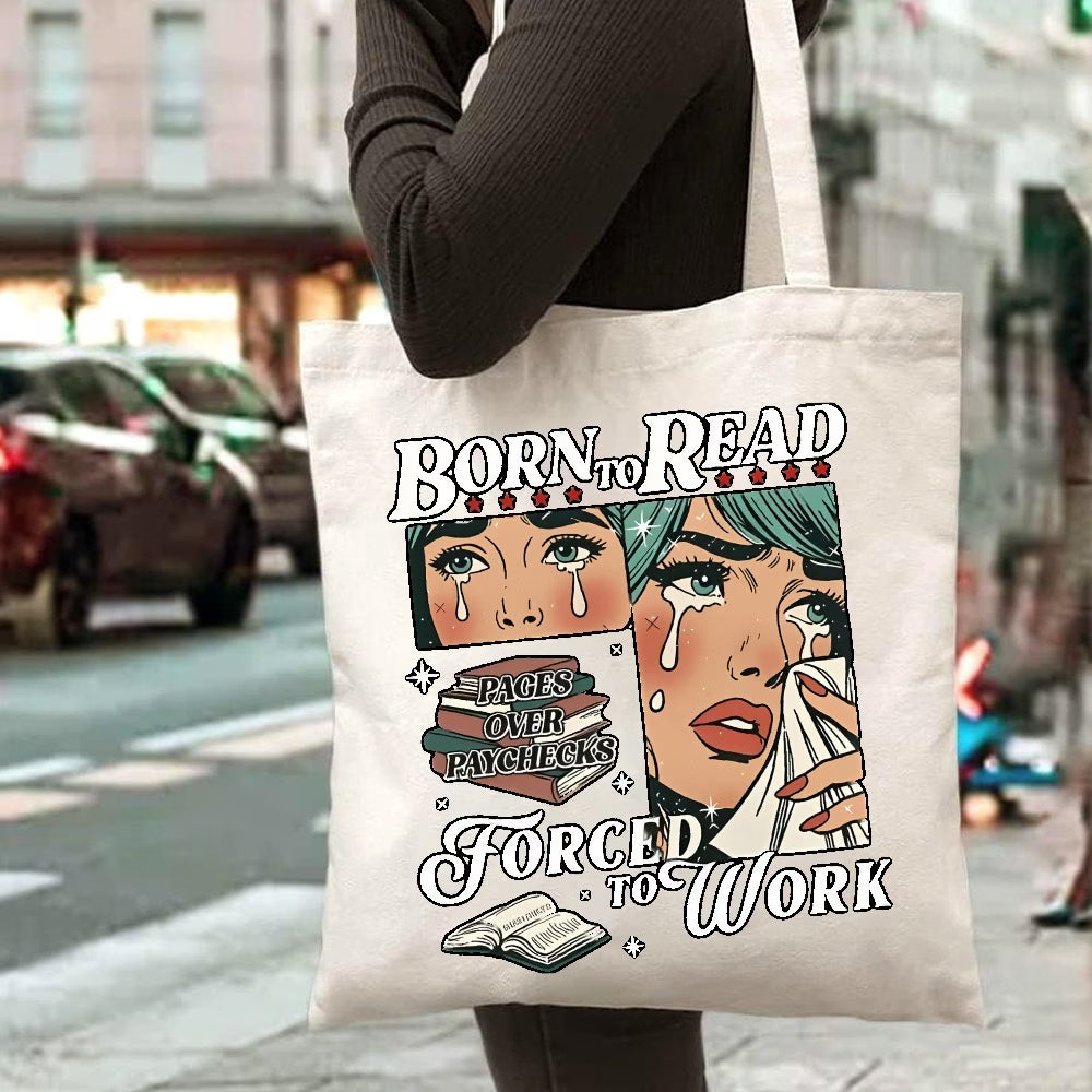 Tote bag with artistic design and text held by a person on a city street.