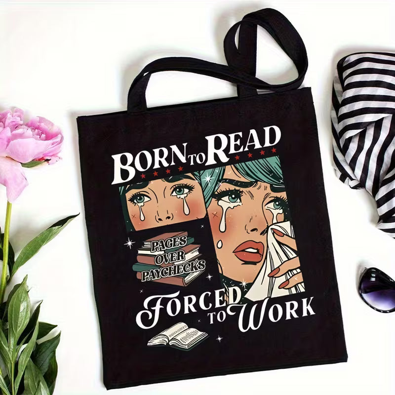 Black tote bag on a white surface with other props nearby for size reference
